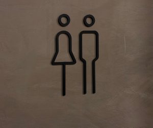 Modern Unisex Restroom Sign on Concrete Wall