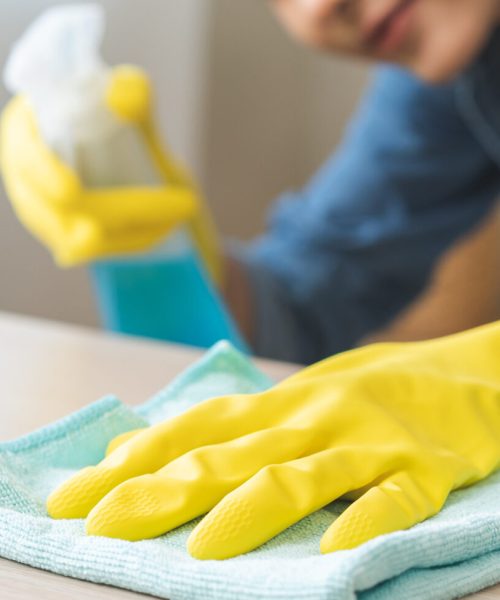 Cleanliness asian young woman working chore cleaning on table at home, hand wearing glove using rag rub remove dust with spray bottle. Household hygiene clean up, cleaner, equipment tool for cleaning